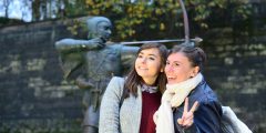 Two students posing by the Robin Hood statue