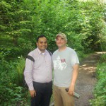 A photograph of Ahilan at Crystal Springs (a tributary of Johnson Creek) with Zac Perry, riparian restoration specialist