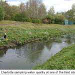 A photo of Charlotte sampling water quality at the side of the River Leen
