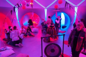 Inside a Luminarium, people sitting inside blue and pink chambers