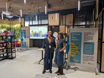 Elizabeth Dolan and Victoria Clare, CEO of Ovacome standing together at their headquarters in front of some banners