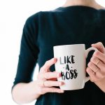 A woman holding a mug which quotes on it "like a boss" to symbolise entrepreneurship