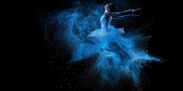 Ballet dancer colour image contrast. Vibrant neon blue colour contrast of ballet clothing onto a black background