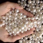 A woman holding a selection of pearls in her hands