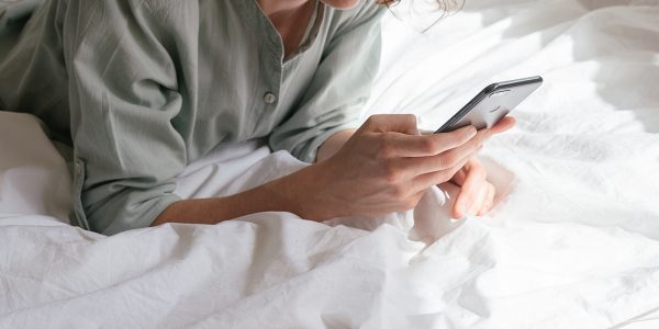 Student using smartphone in bed