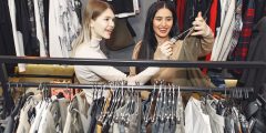 Two females in a clothes shop looking at clothes