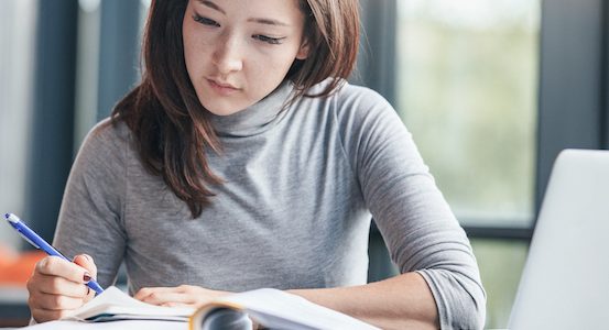 Woman taking down notes in diary