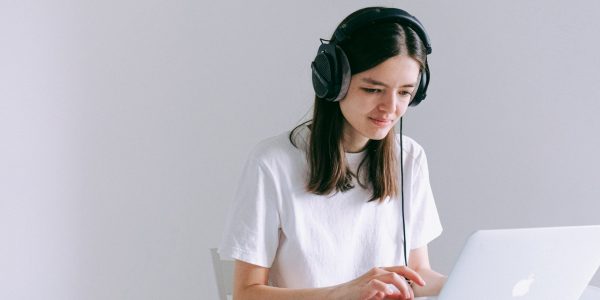 Woman wearing headphones looking at a laptop