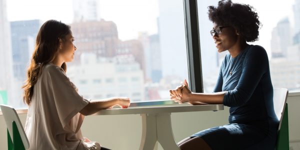 Two women at a table in a discussion