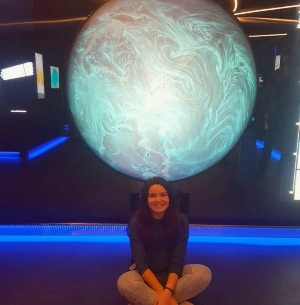 Cristina sitting with a giant globe behind her at the ESA
