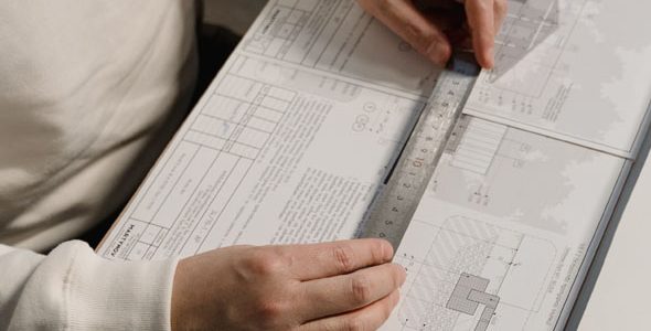 Someone using a ruler on architecture plans