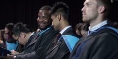 three male students in graduation gowns