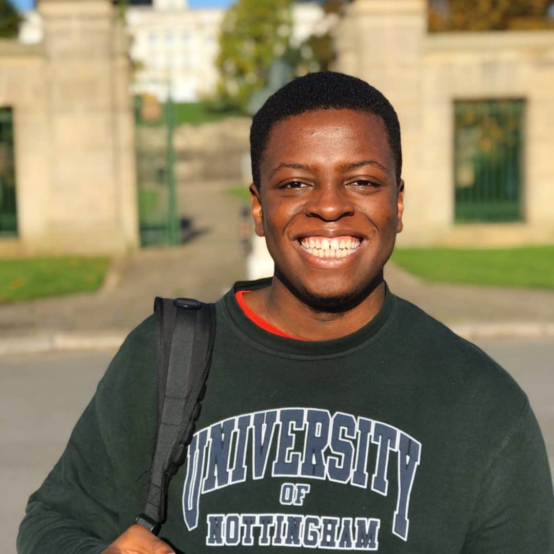 Nottingham student Darryl smiling on campus in a UoN jumper