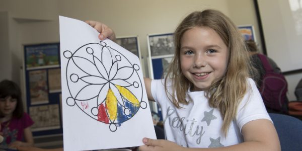 Pupil showing her drawing in a classroom