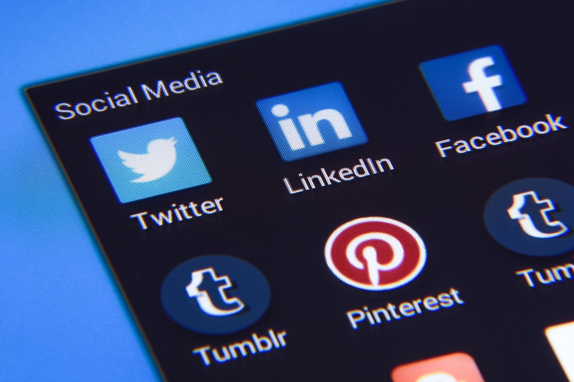 A phone screen displays a page of social media icons, including twitter, LinkedIn, Facebook, Tumblr and Pinterest