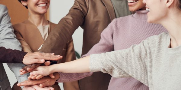A group of people putting hands into a circle and smiling