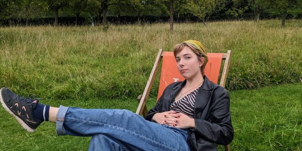 A picture of a girl sat in a chair in a field