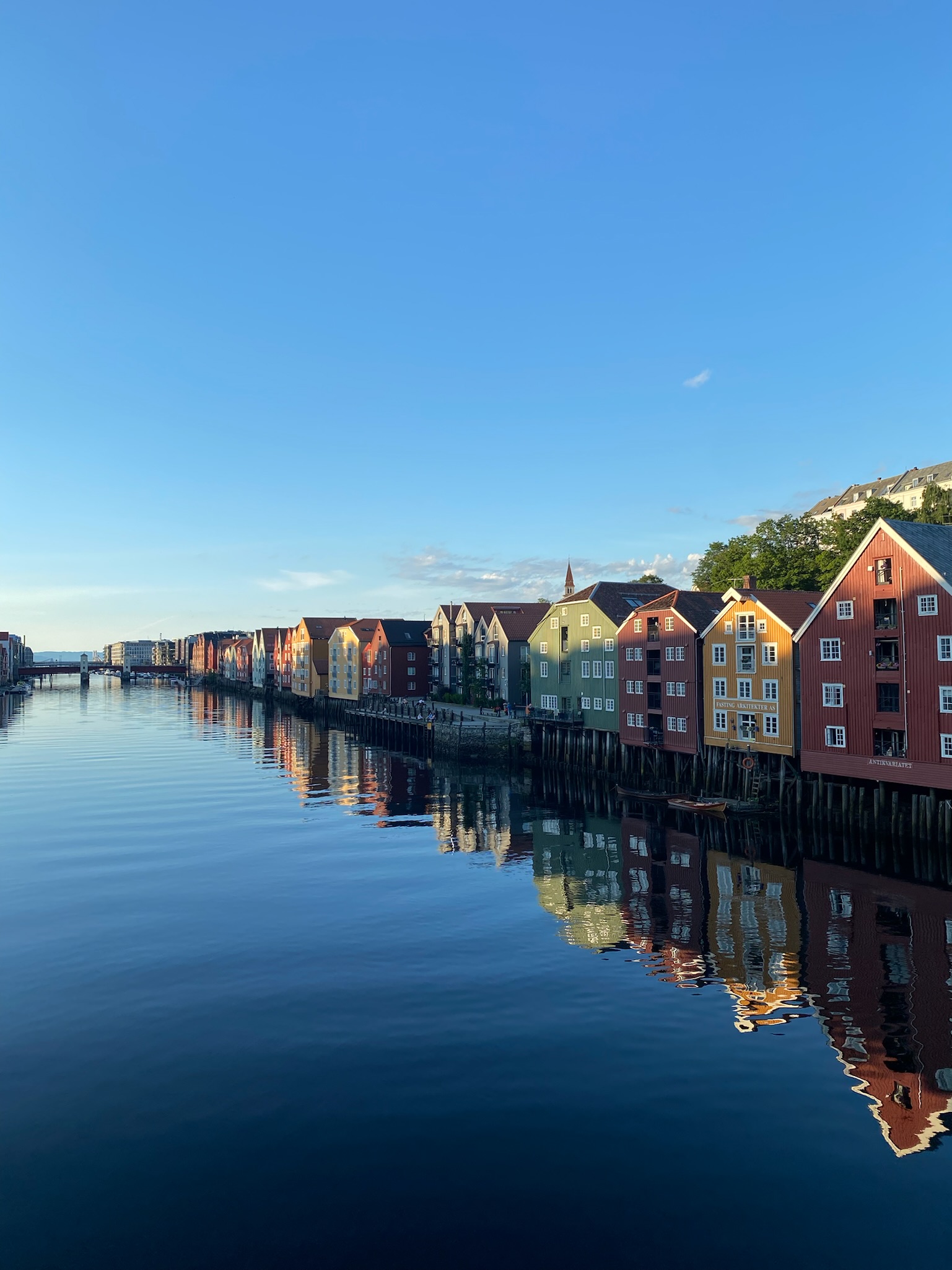 A picture looking down the river at the houses from trondheim old bridge at sunset.