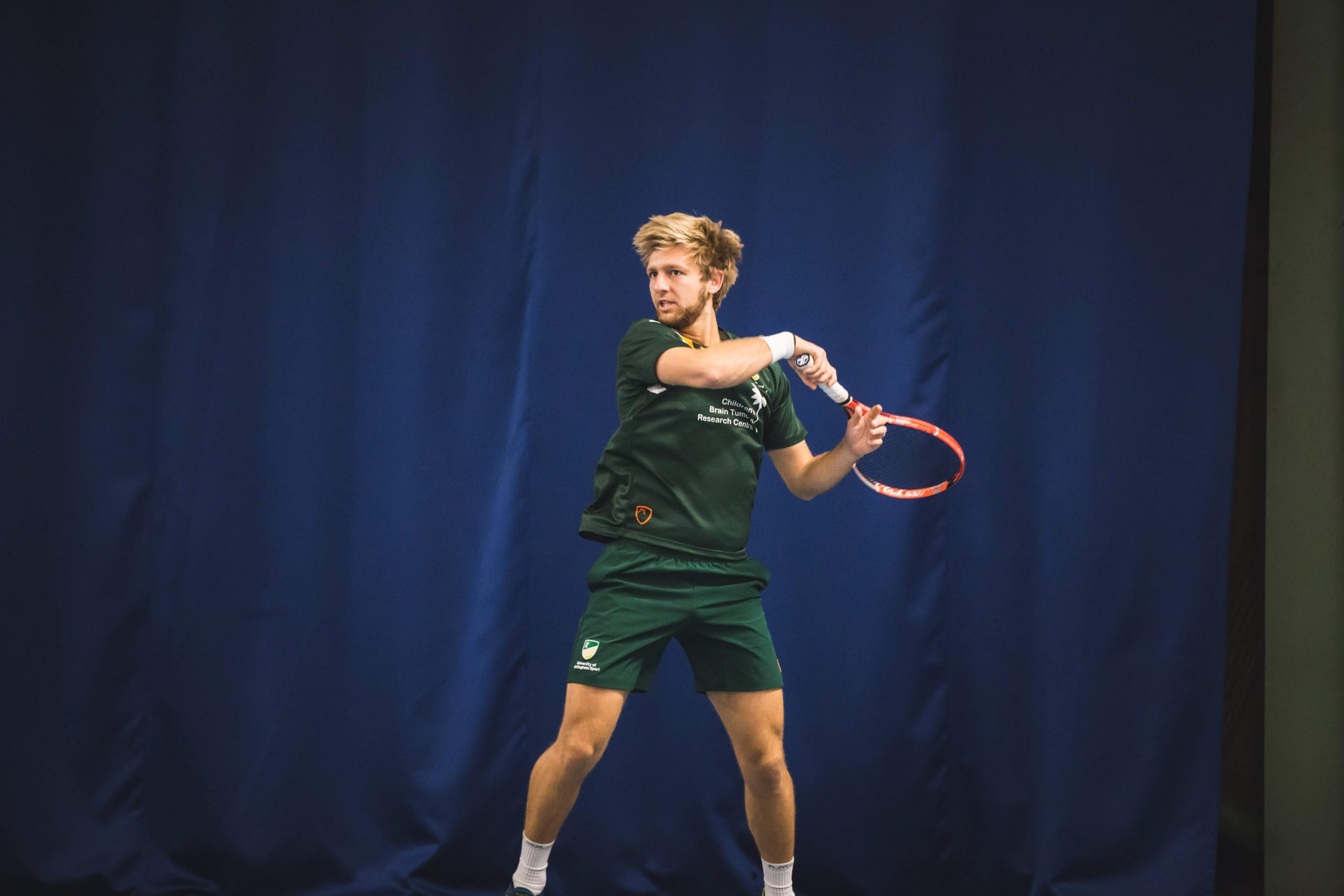 An image of Andrew playing tennis in his Son sports kit