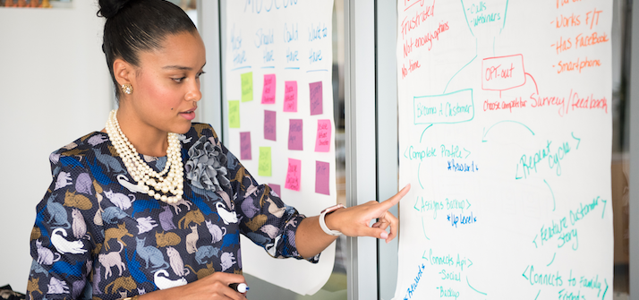 Woman presenting and pointing at a flipchart