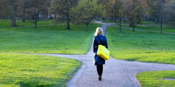 A woman working towards a crossroads of paths