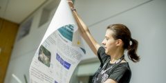 PhD student showing a poster of her research