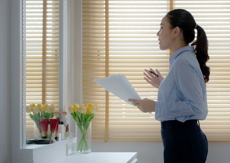 Female student happy standing smiling looking in the mirror preparing for an interview