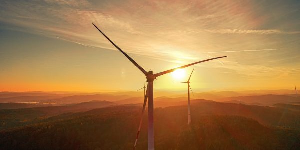 Wind powered windmills in a landscape showing a sunset