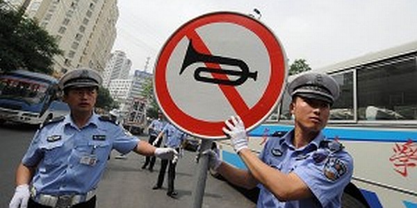 Traffic police in China display a no honking sign to motorists.