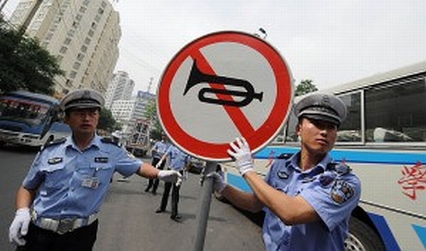 Traffic police in China display a no honking sign to motorists.