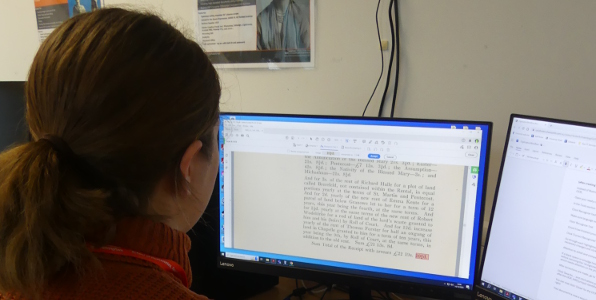 Phoptograph of a student studying a page of text on a PC monitor