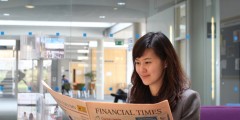 Female postgraduate student reading the Financial Times