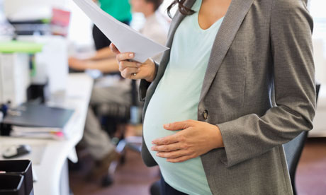Pregnant business woman working in office.