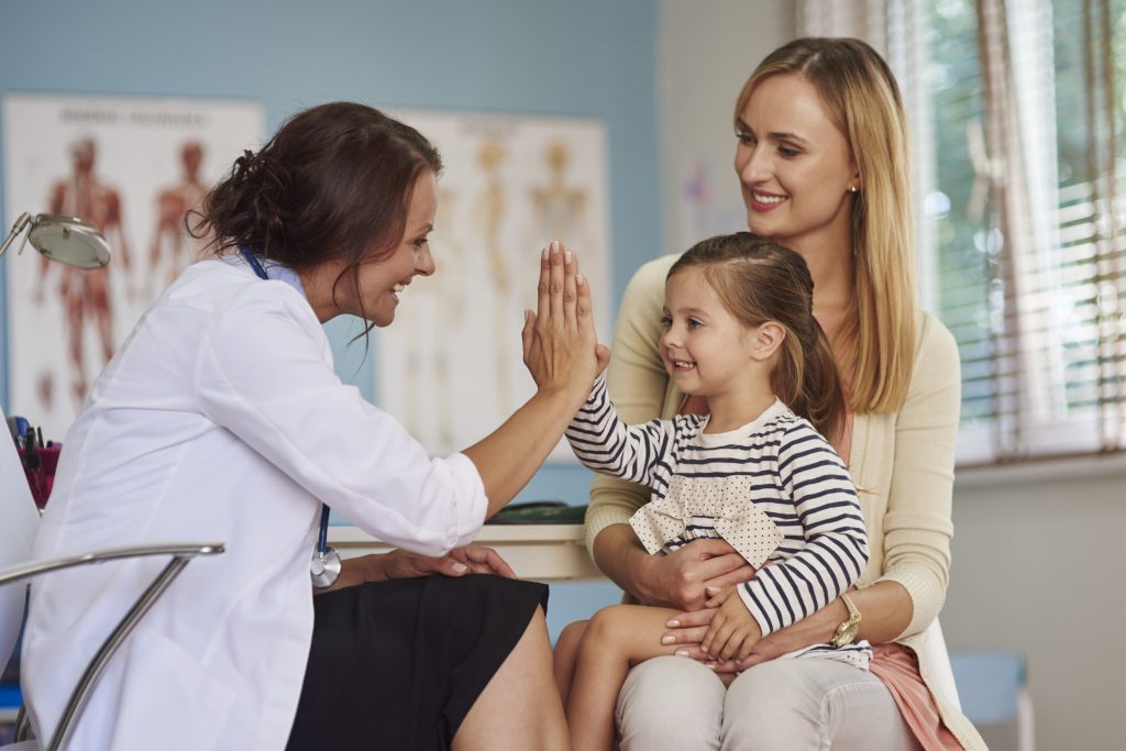 Image showing a doctor clappiung hands with a child sitting on parent's knee