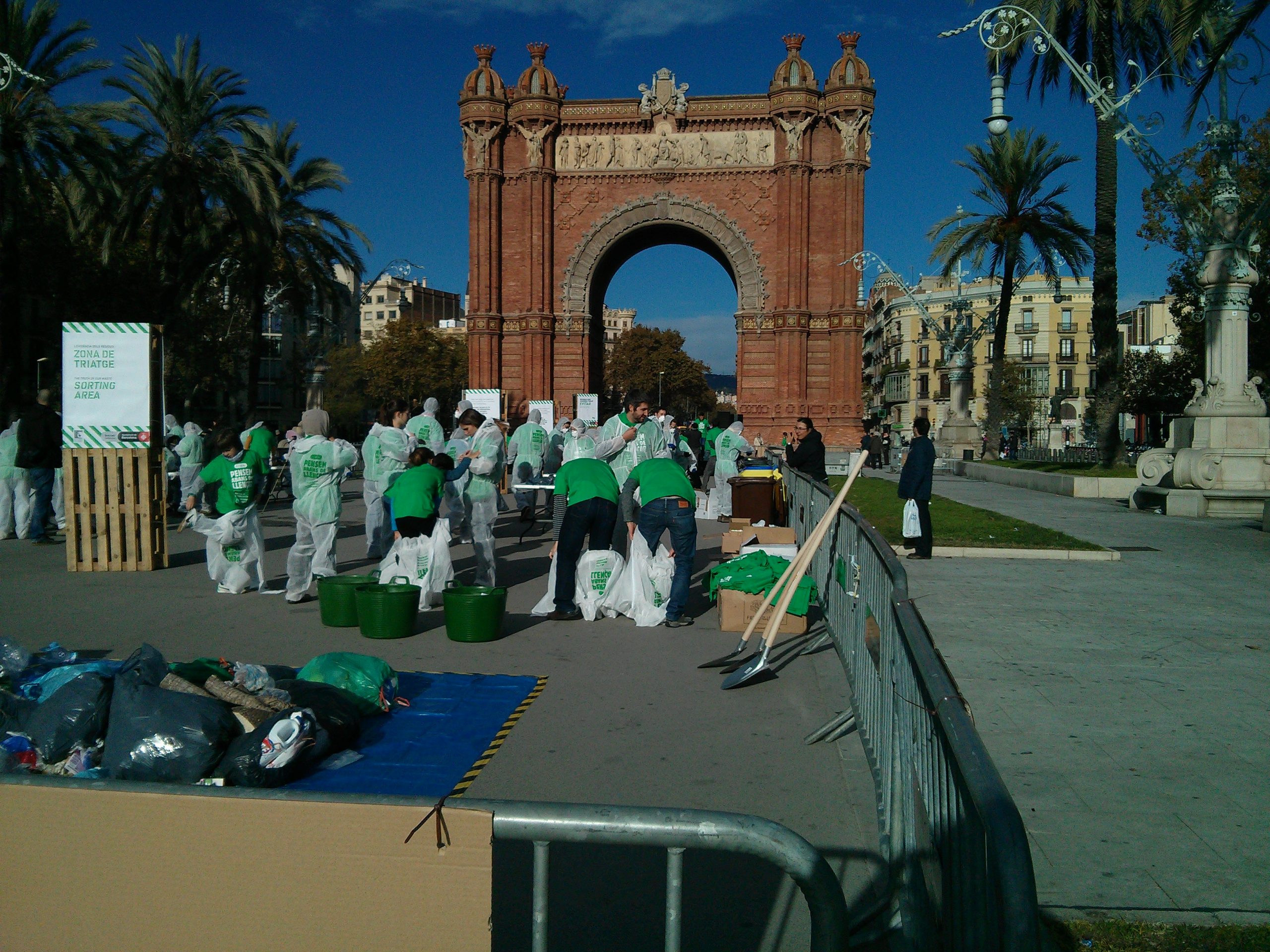 Local residents putting on protective suits surrounded by rubbish bags, preparing for a waste audit in a square in Barcelona