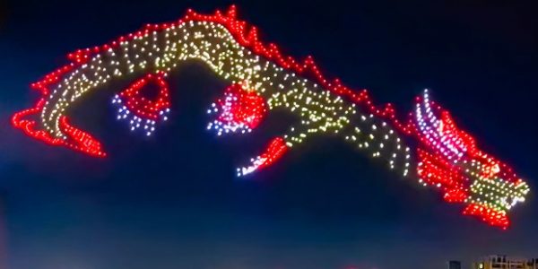 A dragon flying in the night sky created using 1500 red, white and yellow drone lights.