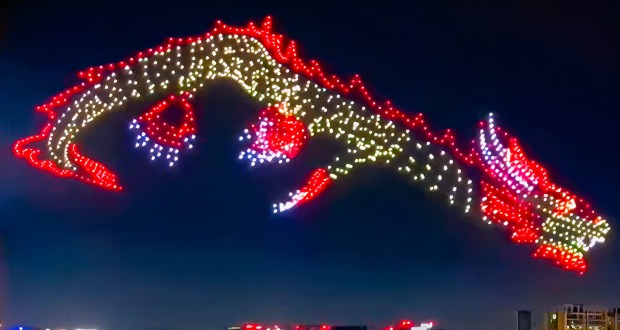 A dragon flying in the night sky created using 1500 red, white and yellow drone lights.