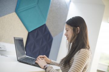 Student typing on a laptop.