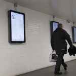 Poetry in Nottingham Public Places , man walking past display screens
