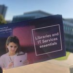 A copy of the Libraries and IT Services essentials guide with George Green Library in the background