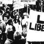 Black and white image of protesters holding banners which read Lesbian Liberation
