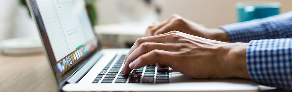 Close up of hands typing on a laptop