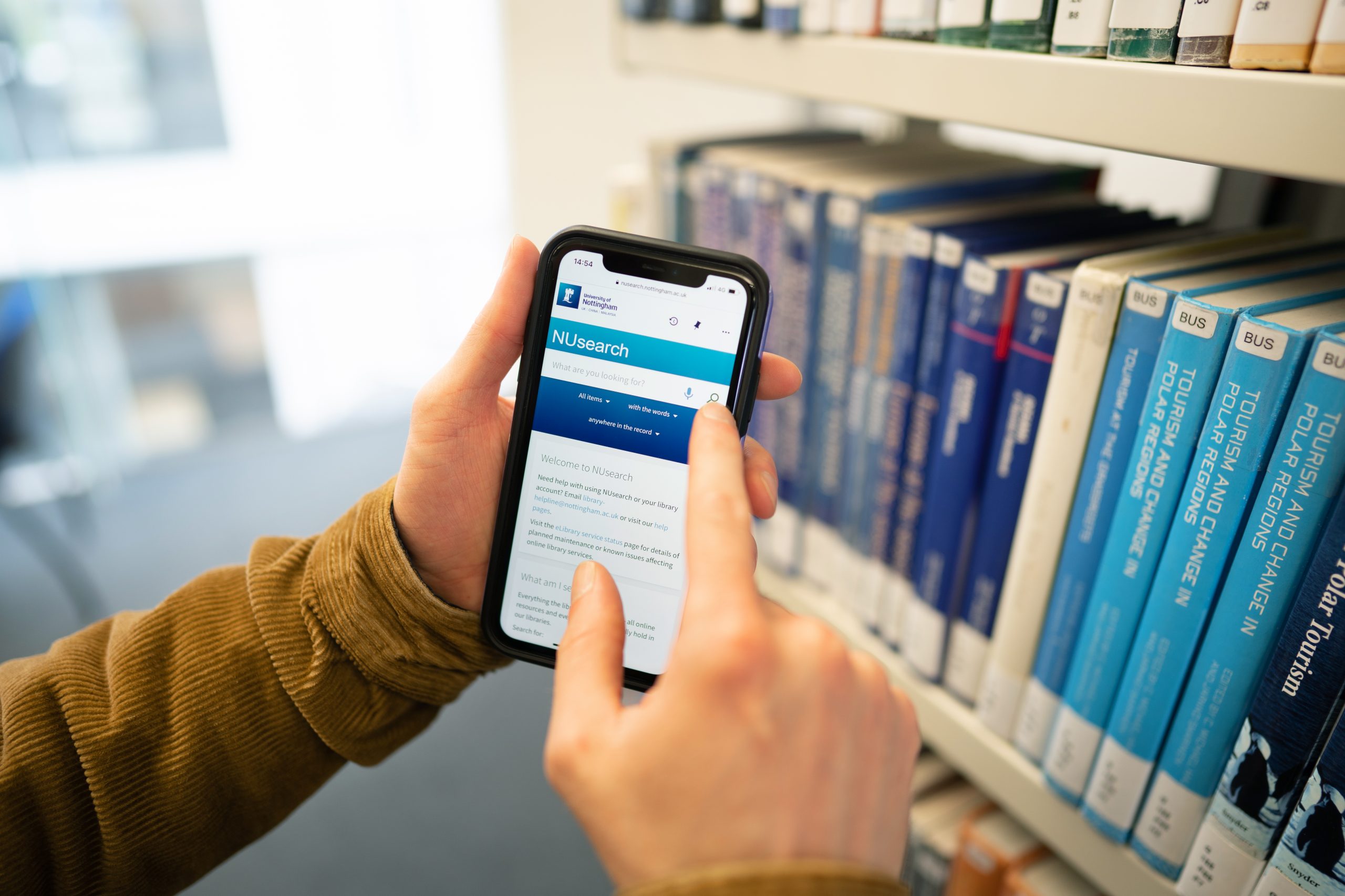 Close up of a person using Nusearch on a mobile phone