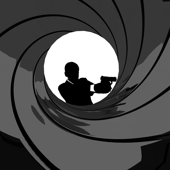 Iconic black and white James Bond image with Bond holding a gun and standing in the middle of a swirling gun barrel