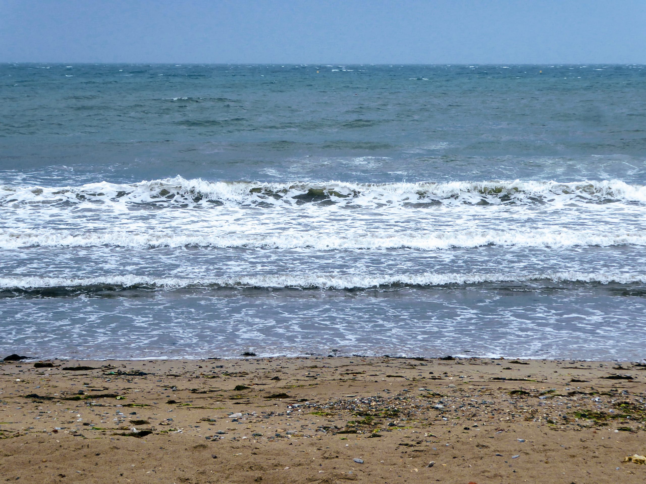 Photo of waves hitting a sandy beach