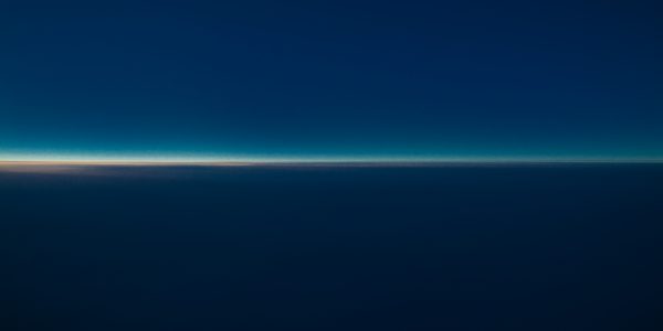 photo of a horizon dark blue then line of light then light blue