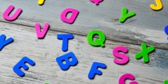 plastic alphabet letters in various colours strewn over a table