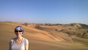 Ursula in headwrap and sunglasses in the Namib desert with sand dunes in the background