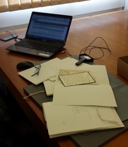 Desk in the Reading Room with laptop, magnifying glass and the documents laid out on foam supports