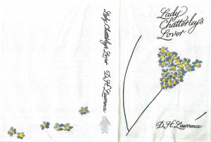 Front cover of the book, which is plain white, title and author sewn in black thread, and decorated with blue and yellow flowers on a stem suggesting female genitals